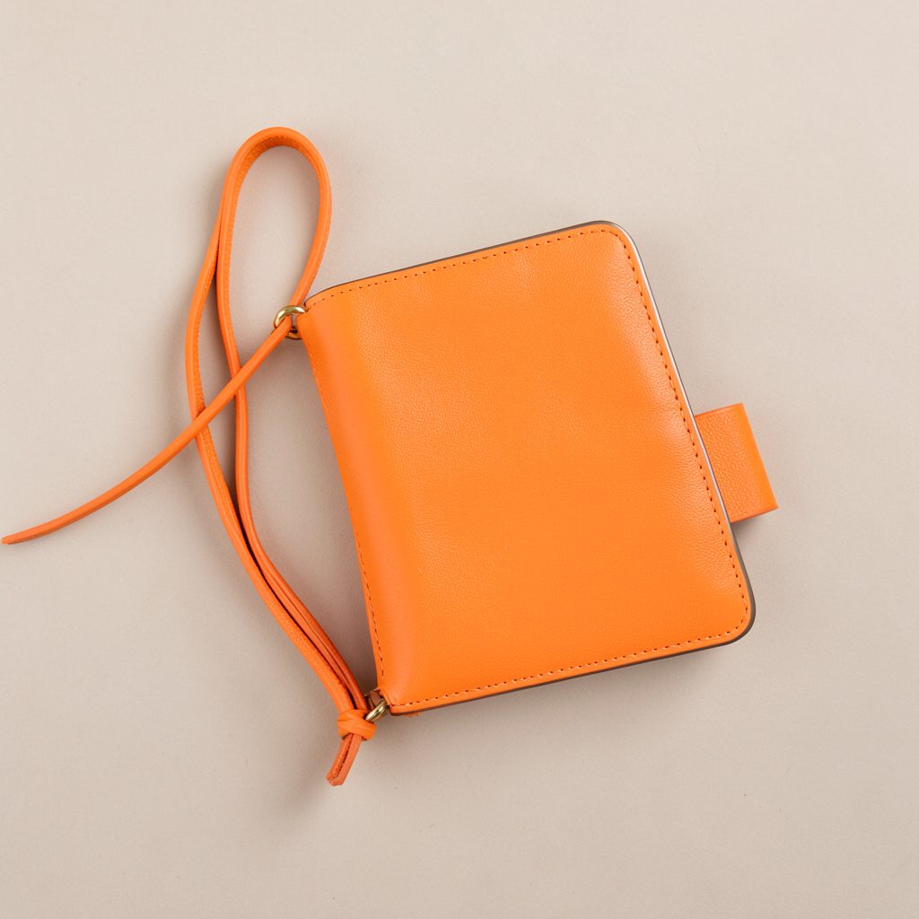 Logotipo de plumshoponline.com, cartera de mano en tonos crema y marrón sobre fondo claro